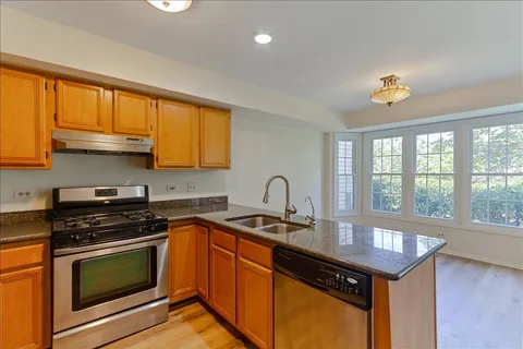 a kitchen with granite countertop a stove a sink and a microwave