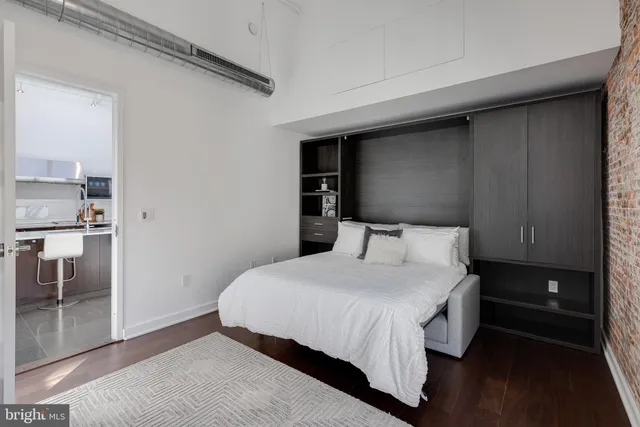 a bedroom with a bed and wooden floor