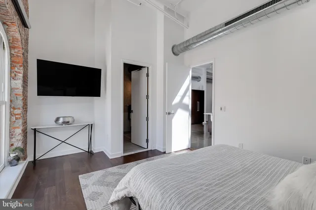 a bedroom with a bed and a flat screen tv