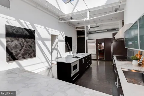 a kitchen with stainless steel appliances kitchen island granite countertop a stove and a sink