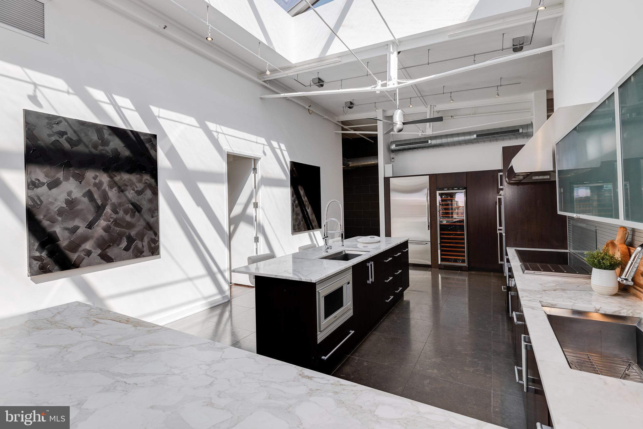 105-32 South 12th Street, Unit PH504 Philadelphia, PA 19107 - Photo 8 of 45 a kitchen with stainless steel appliances kitchen island granite countertop a stove and a sink