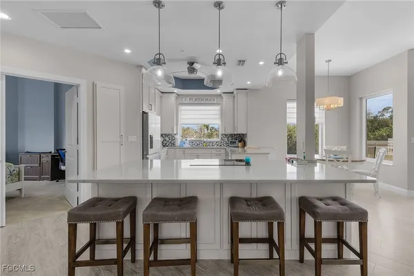 a kitchen with granite countertop a table chairs stove and cabinets