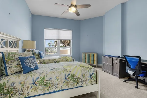 a bed sitting in a bedroom next to a window with a bookshelf