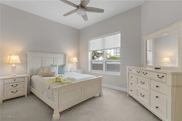 a spacious bedroom with a bed a dresser and a window