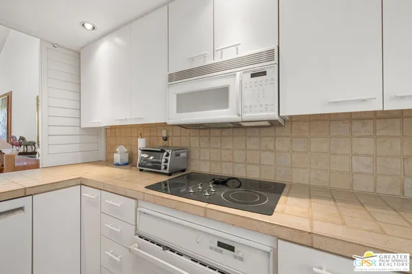 a kitchen with a white cabinets and window