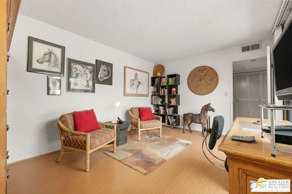 a bedroom with a bed and a flat tv screen on the dresser