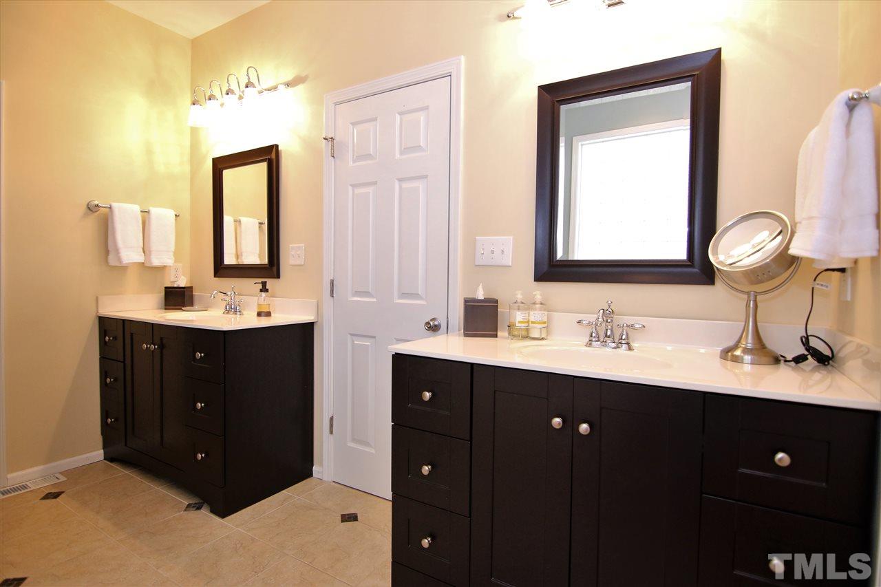 5976 Elevation Road Benson, NC 27504 - Photo 13 of 25 a bathroom with a double vanity sink and mirror