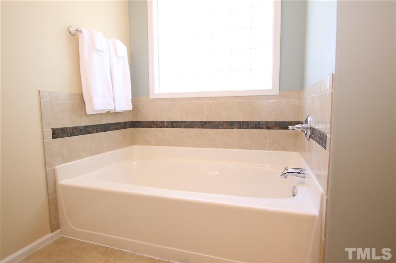 5976 Elevation Road Benson, NC 27504 - Photo 14 of 25 a bathroom with bathtub and window