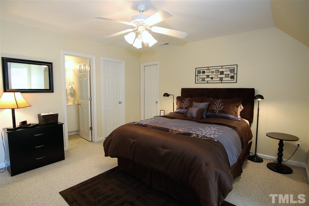 5976 Elevation Road Benson, NC 27504 - Photo 20 of 25 a bedroom with a bed and a chandelier