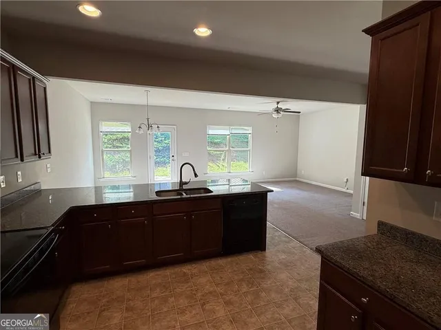 a large kitchen with granite countertop a sink and cabinets