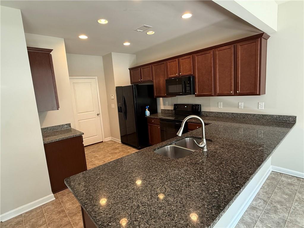 149 Hardy Water Drive Southeast Lawrenceville, GA 30045 - Photo 5 of 5 a kitchen with stainless steel appliances granite countertop a table and a refrigerator