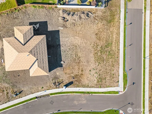 an aerial view of ocean and residential houses with outdoor space