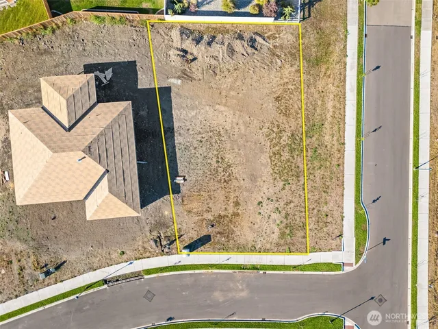 an aerial view of ocean and residential houses with outdoor space