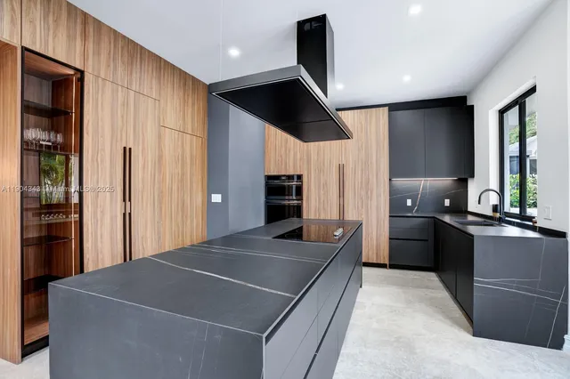 a kitchen with stainless steel appliances kitchen island granite countertop a refrigerator and a sink