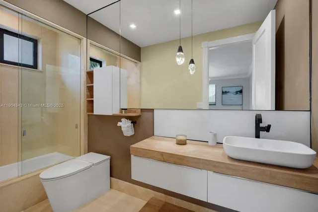 a bathroom with a granite countertop sink toilet and shower
