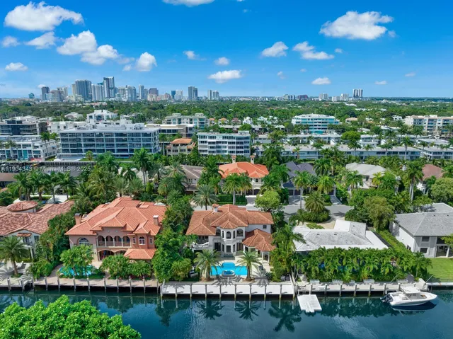 an aerial view of residential houses with outdoor space and lake view