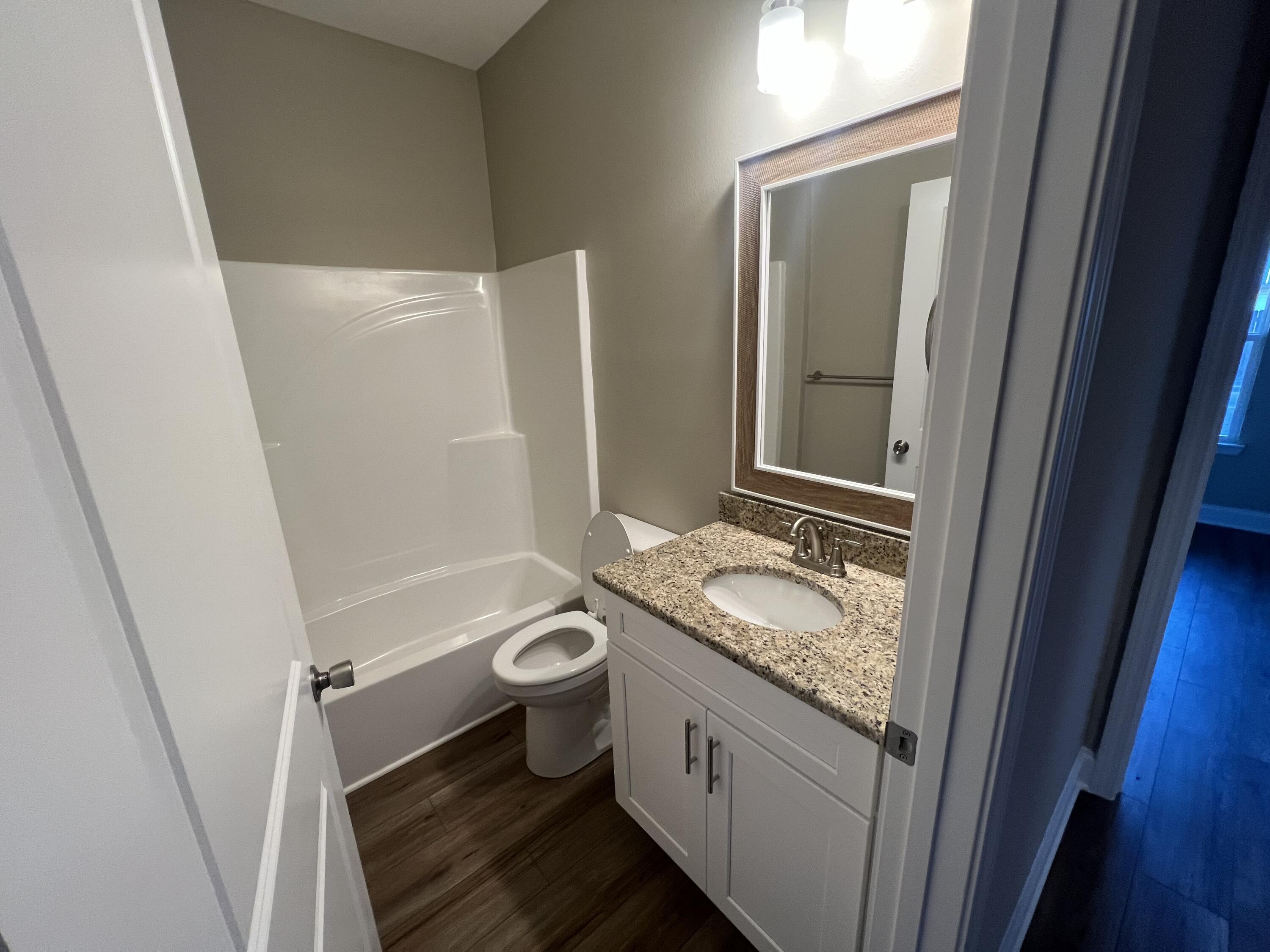 89 Hawkins Road Fort Walton Beach, FL 32547 - Photo 11 of 12 a bathroom with a granite countertop sink toilet and shower