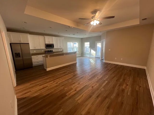 a large kitchen with a wooden floor and stainless steel appliances