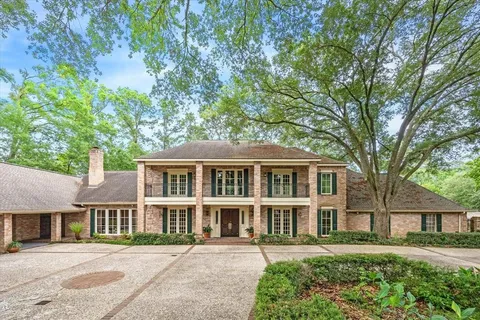 front view of a brick house with a yard