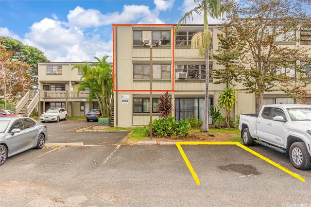 a view of a cars park in front of a building