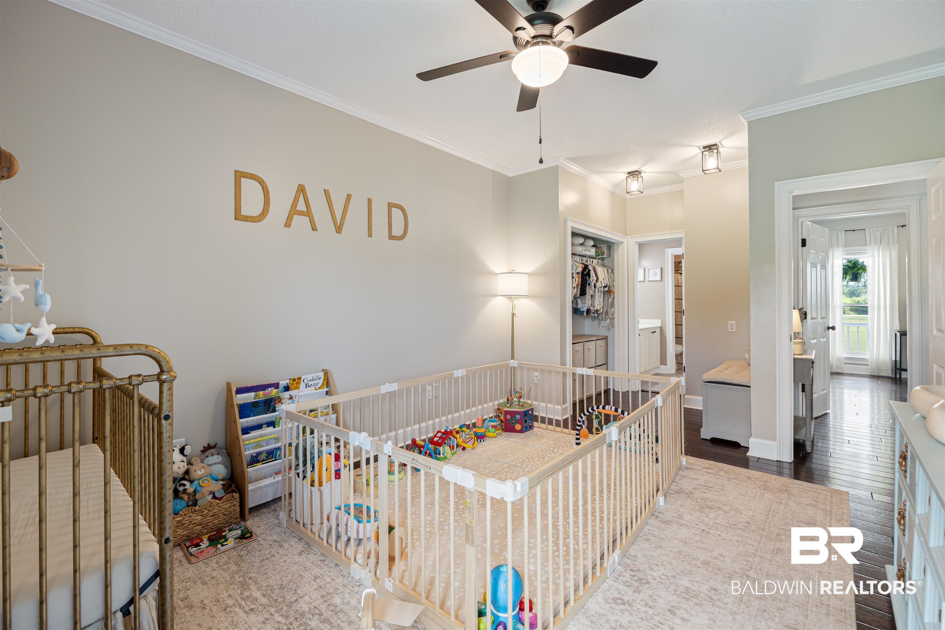 9855 Stucki Road Elberta, AL 36530 - Photo 38 of 54 Bedroom featuring dark wood finished floors, ornamental molding, ceiling fan, ensuite bathroom, and a crib
