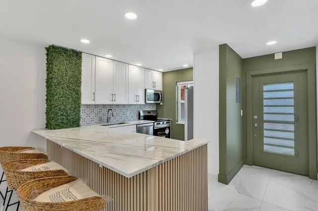a kitchen with granite countertop sink and refrigerator
