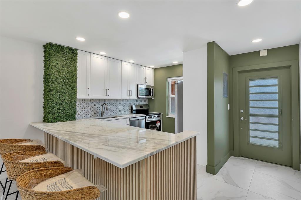 9818 Marina Boulevard, Unit 1225 Boca Raton, FL 33428 - Photo 3 of 17 a kitchen with stainless steel appliances kitchen island a large counter top space and cabinets