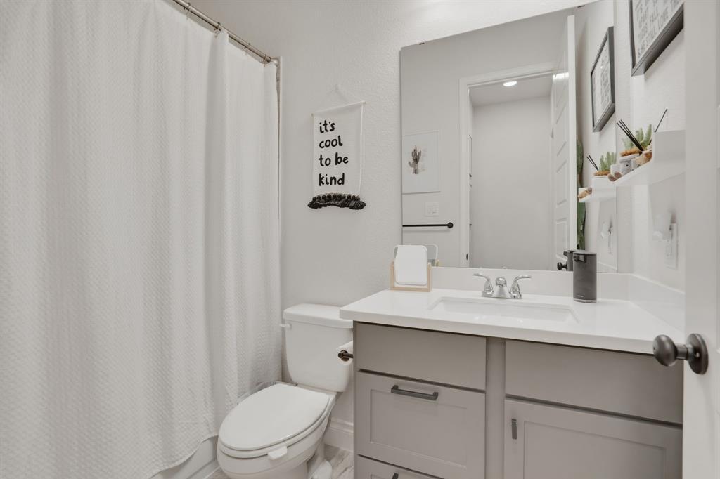 904 Fallbrook Avenue Denton, TX 76210 - Photo 23 of 30 a bathroom with a sink a toilet and a mirror