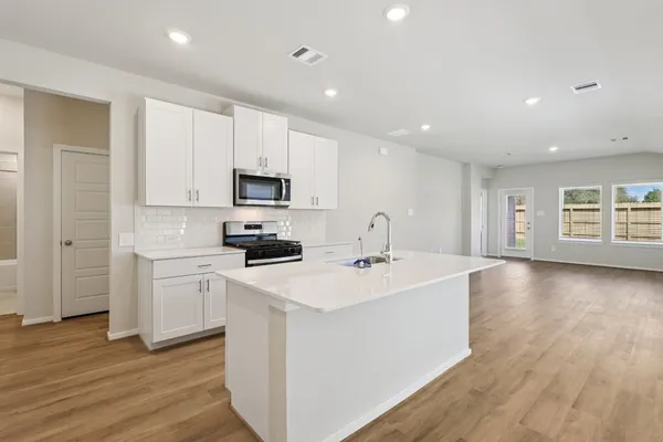 a kitchen with appliances a sink and a microwave