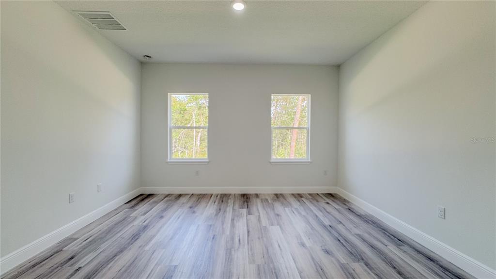15625 Southwest 37th Circle Ocala, FL 34473 - Photo 24 of 27 an empty room with wooden floor and windows