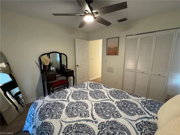 a bedroom with a bed and a mirror on dresser