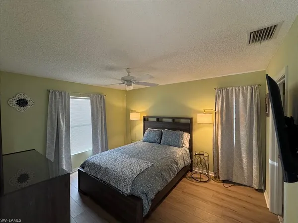 a bedroom with a large bed and a chandelier