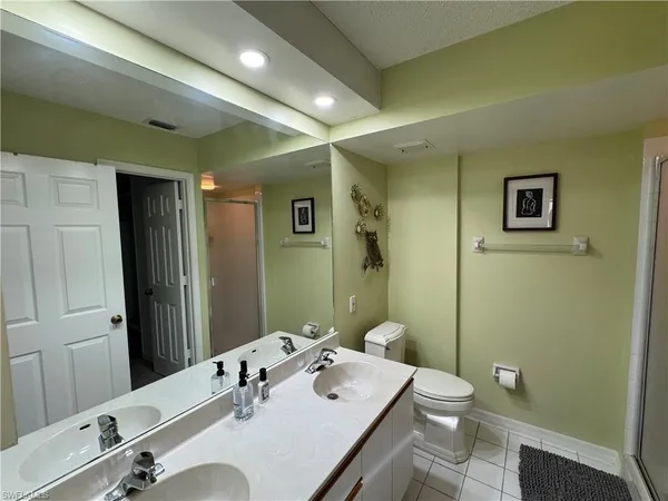 a bathroom with a granite countertop sink a toilet and a mirror