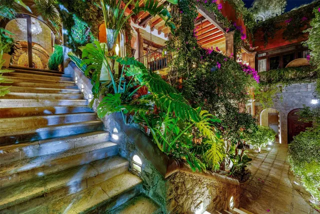 a living room with furniture a fireplace and lots of windows