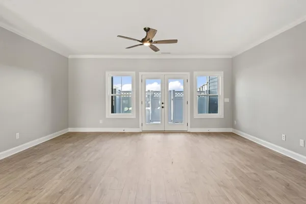 a view of an empty room with a window and wooden floor