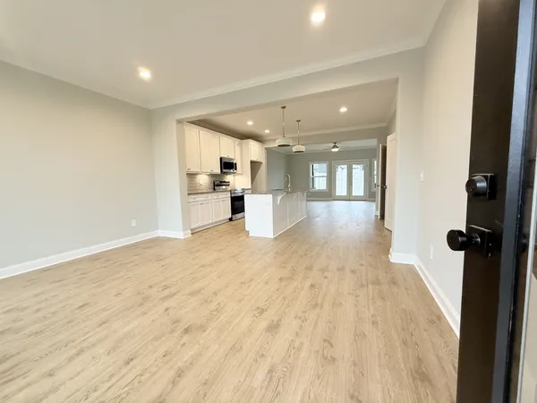 a view of a big room with wooden floor and windows