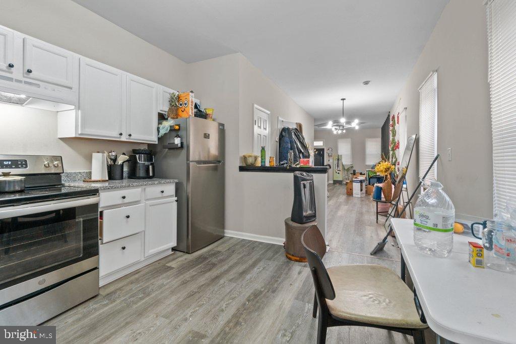 701 Baker Street Baltimore, MD 21217 - Photo 11 of 26 a view of a kitchen with furniture and wooden floor