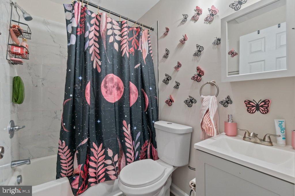 701 Baker Street Baltimore, MD 21217 - Photo 21 of 26 a bathroom with a toilet and a shower curtain