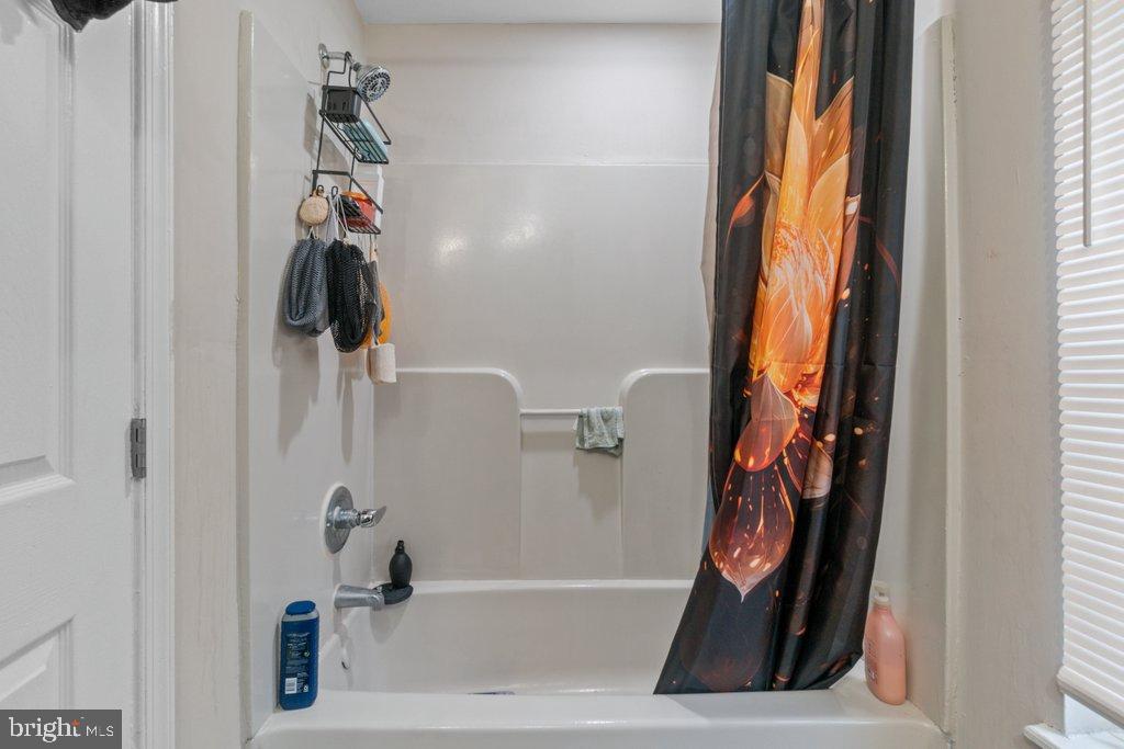 701 Baker Street Baltimore, MD 21217 - Photo 24 of 26 a bathroom with a bathtub and a shower