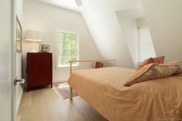a bedroom with a bed and wooden floor