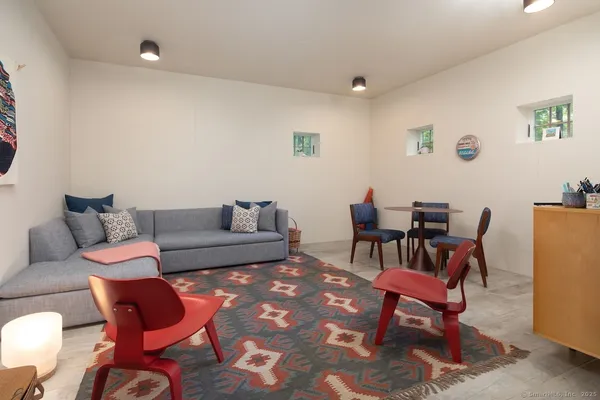 a living room with furniture a rug and a dining table