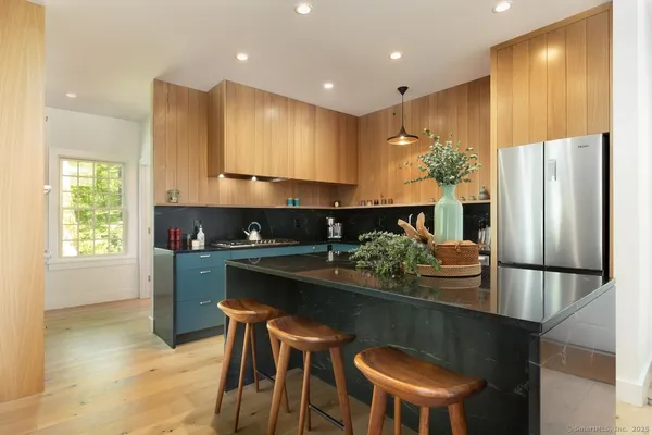 a kitchen with stainless steel appliances granite countertop a sink and a refrigerator