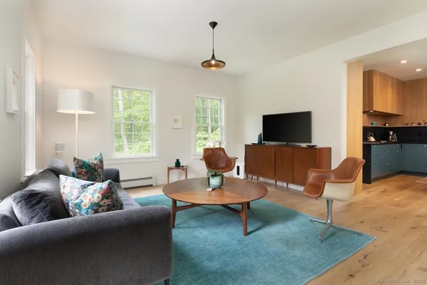 a living room with furniture a window and a flat screen tv