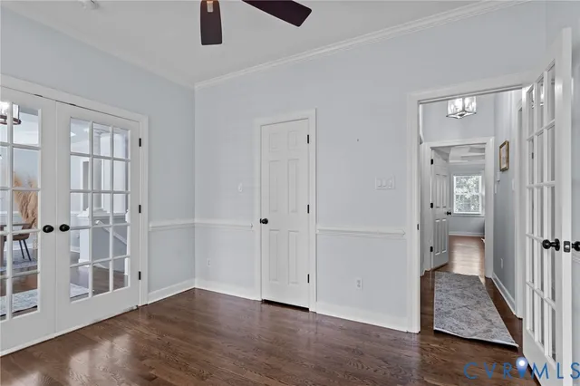 an empty room with wooden floor cabinet and windows