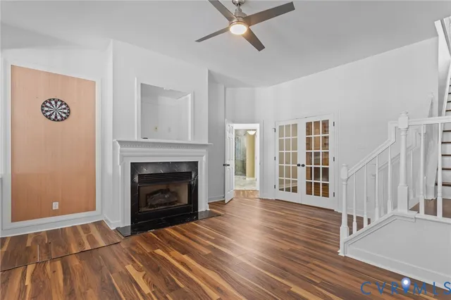 a view of a livingroom with wooden floor a fireplace and windows