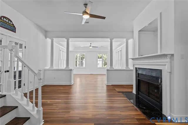a view of a livingroom with wooden floor fireplace and a window