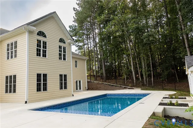 a view of a white house with a swimming pool and sitting area