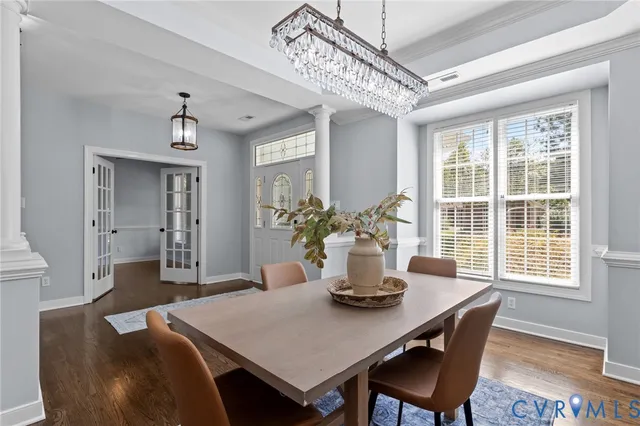 a dining room with furniture a chandelier and wooden floor
