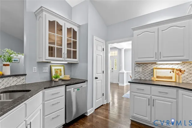 a kitchen with granite countertop white cabinets and white appliances