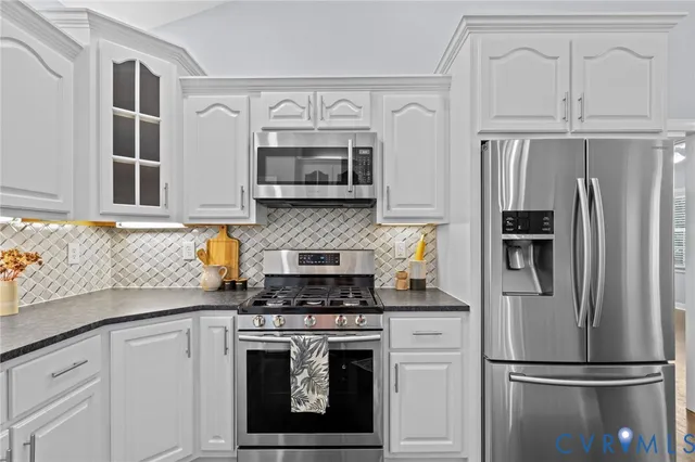 a kitchen with cabinets stainless steel appliances and a counter space